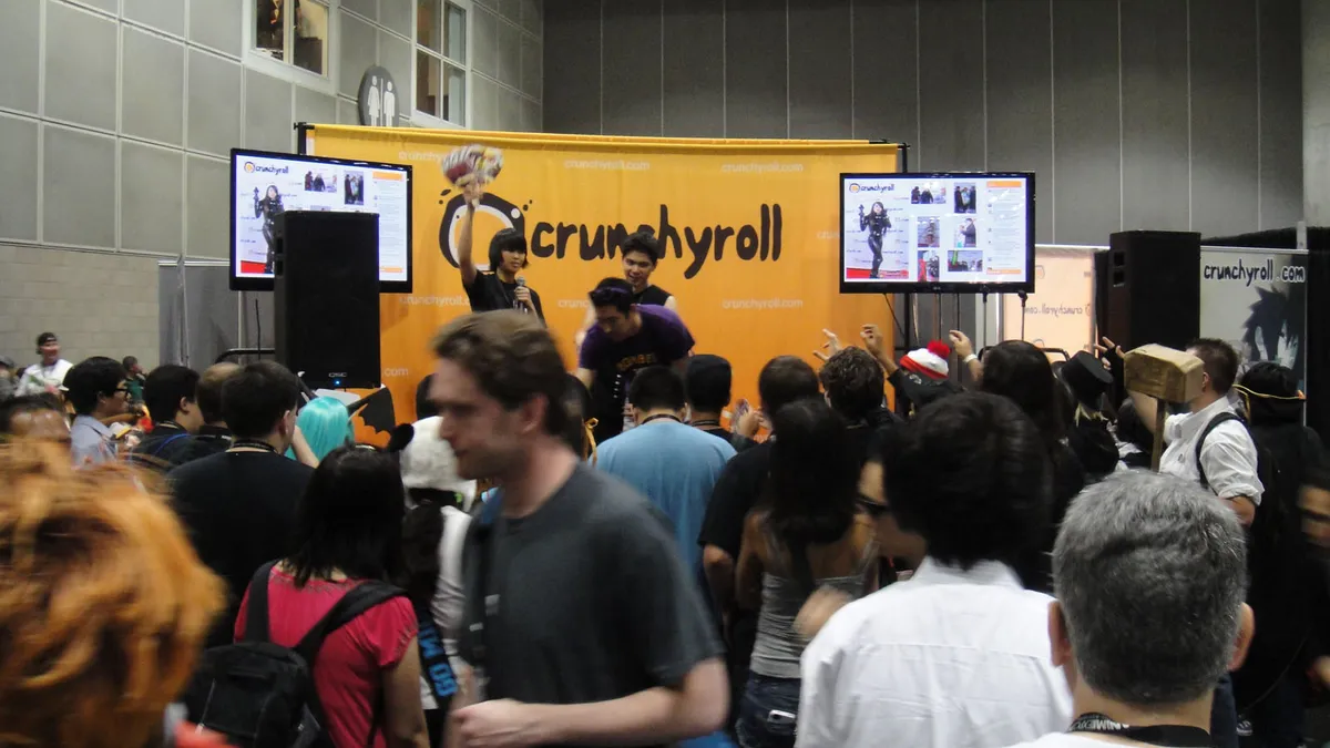 Fans crowding the orange Crunchyroll booth at Anime Expo in Los Angeles