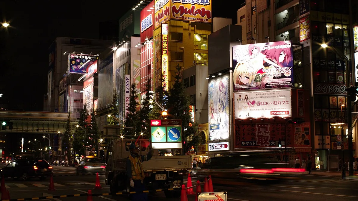Giant anime billboards lit up at night above a street in Akihabara, Tokyo